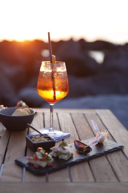 Italian aperitif at the sunset by the sea - What you eat: a real aperitivo spread built from local ingredients